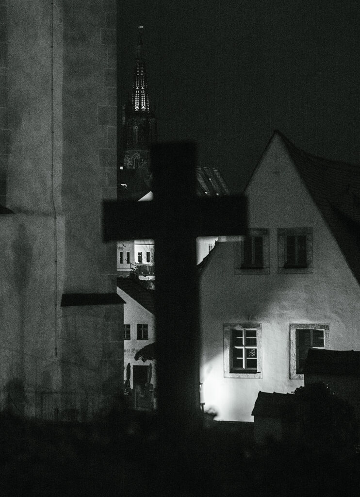 Kreuz vor Kirche bei Nacht