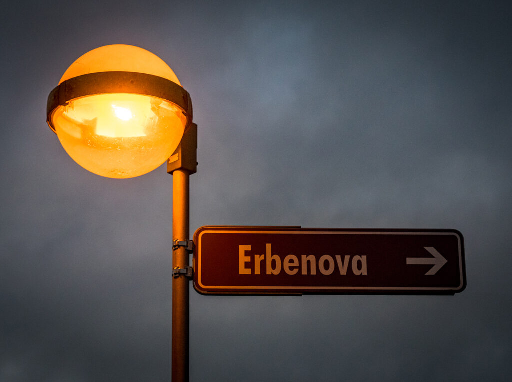 brennende Straßenlampe und Straßenschild