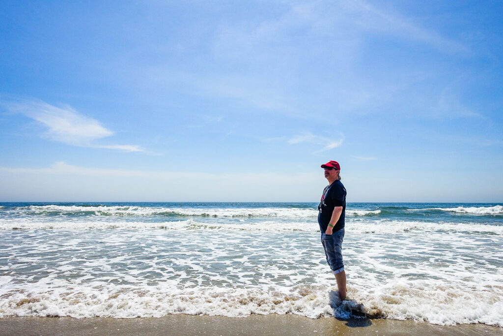 Mann steht am Meeresufer